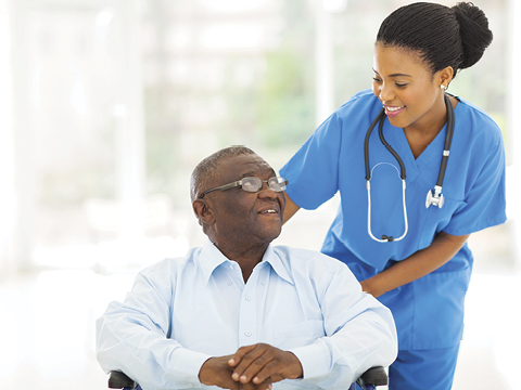 African nurse taking care of senior patient in wheelchair